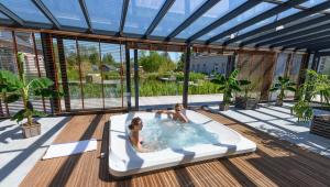 two people in a hot tub on a deck at Domaine de Diane in Quend-Plage