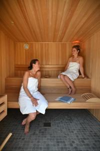 twee vrouwen zitten in een sauna bij Domaine de Diane in Quend-Plage