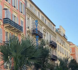 un bâtiment avec un panneau sur son côté dans l'établissement Hôtel Helvétique, à Nice