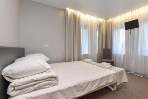 a bedroom with a large bed with white sheets at Palanga Centrum in Palanga