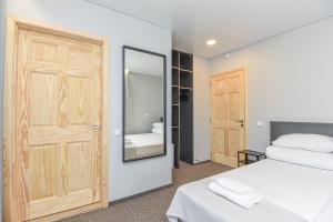 1 dormitorio con cama blanca y espejo en Palanga Centrum en Palanga