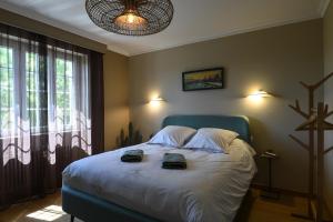 a bedroom with a bed with two shoes on it at Entre Terre et Mer in Plougoulm