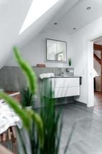 ein Bad mit einem Waschbecken und einem Spiegel in der Unterkunft Almer Schlossmühle in Brilon