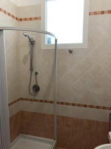 a shower with a glass door in a bathroom at La Casa Sulla Scogliera in Cefalù