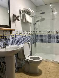 a bathroom with a toilet and a sink and a shower at La Habana Apart Hotel in Lloret de Mar