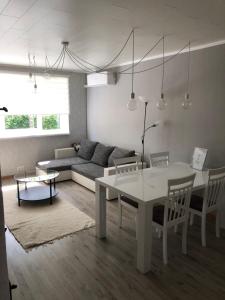 ein Wohnzimmer mit einem weißen Tisch und einem Sofa in der Unterkunft Soelaane 12 Apartments in MikitamÃ¤e