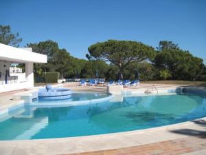 una gran piscina con sillas azules. en By the Beach en Almancil
