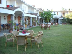 un grupo de sillas y mesas en un patio en Hotel Domu Incantada en Muravera