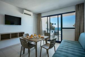 een kamer met een tafel en stoelen en een kamer met uitzicht bij Pins Platja Apartments in Cambrils
