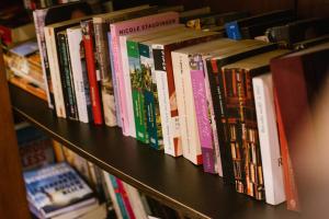 una fila de libros en un estante de una librería en Hotel Kavala - Boutique Hotel en Prínos