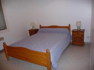 - une chambre avec un lit en bois et 2 tables de chevet dans l'établissement le marais, à LʼÉguille