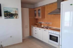 a kitchen with white cabinets and a sink at VILLA LA TEGALA in Caleta de Sebo