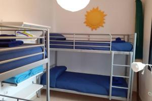 - łóżko piętrowe z niebieskimi łóżkami piętrowymi w pokoju w obiekcie VILLA LA TEGALA w mieście Caleta de Sebo