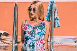 a woman in a swimsuit and sunglasses in a swimming pool at Stefania Studios by Estia in Stalís