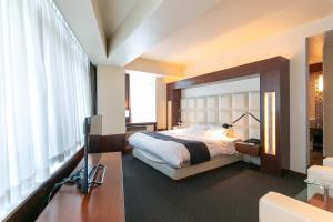 a bedroom with a bed and a large window at HOTEL APERTO (Adult Only) in Tokyo