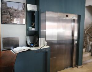 a metal refrigerator in a room with a book on a counter at Hostal Cuéntame Evolución Auto Check in in Burgos