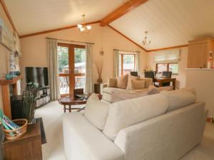 a living room with a white couch and a table at Crocus Lodge in Bodmin