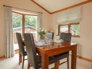 a dining room with a wooden table and chairs at Crocus Lodge in Bodmin