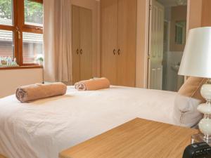 a bedroom with a bed with two towels on it at Crocus Lodge in Bodmin