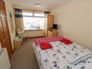 a bedroom with a bed with red towels on it at Min Y Traeth in Amlwch