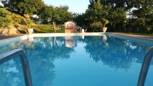 a swimming pool with a large white swimming pool behind it at Agriturismo La Manonera in Montepulciano