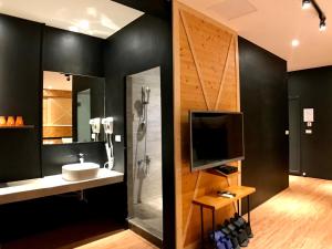 bagno con doccia, lavandino e TV di Martin Wales Inn a Kenting
