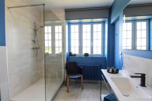 a bathroom with a shower and a sink and a chair at Entre Terre et Mer in Plougoulm +21 photos
