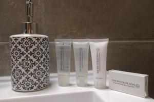 un lavandino in bagno con due tubi di plastica adesivi accanto a uno spazzolino da denti di AmberHuis a Kasterlee Altre 25 foto