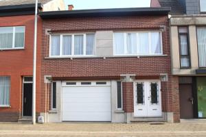 una casa in mattoni rossi con porte bianche in garage di AmberHuis a Kasterlee