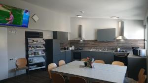 a kitchen with a table and a tv on the wall at Landgasthof und Pension Zum löwen in Bischofsheim an der Rhön