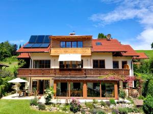 una casa con paneles solares en el techo en Apartment Sonnenfeld en Samerberg