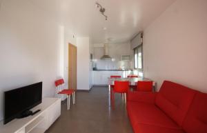 uma sala de estar com um sofá vermelho e cadeiras vermelhas em Apartamentos Mirador de Reis em Sanxenxo