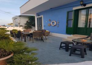 un patio con mesas y sillas y un edificio azul en Rosa Dei Venti Ponza en Ponza