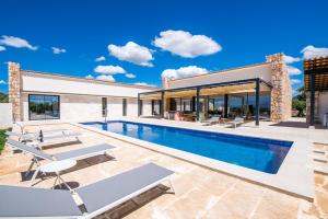 een villa met een zwembad en een huis bij Pura Vida in Ariany