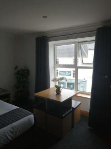 a bedroom with a desk in front of a window at Reveller Lodgings in Donegal