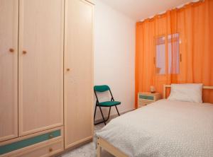 Bright apartment close to congress center & port في برشلونة: غرفة نوم فيها سرير وكرسي