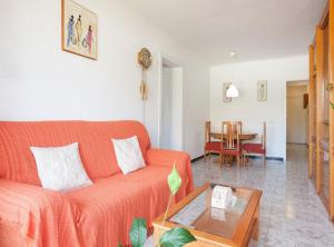 Bright apartment close to congress center & port في برشلونة: غرفة معيشة مع أريكة برتقالية وطاولة