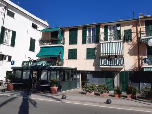 a building with green doors and balconies on a street at House La Baia delle Favole by Holiday World in Sestri Levante