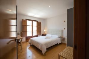 1 dormitorio con cama blanca y ventana en Pucela apartmets en Valladolid