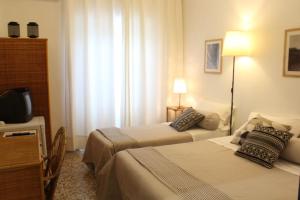 a hotel room with two beds and a television at Rosa Dei Venti Ponza in Ponza