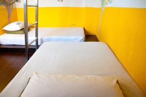 two beds in a room with a yellow wall at Heng-zhan Inn in Hengchun