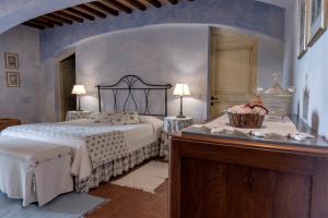 um quarto com uma cama e uma mesa num quarto em Il Borghetto Tuscan Holidays em San Gimignano