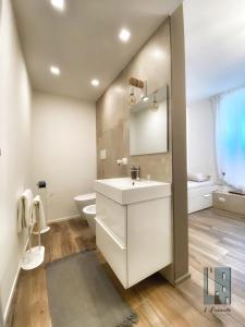La salle de bains blanche est pourvue d'un lavabo et de toilettes. dans l'établissement L'ArChasetta Historic Apartments, à Casamassima