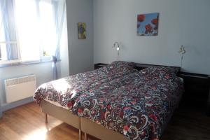 - une chambre avec un lit doté d'une couette rouge et noire dans l'établissement Domaine du Sable, à Saint-Julien-aux-Bois