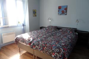 a bedroom with a bed with a red and black comforter at Domaine du Sable in Saint-Julien-aux-Bois