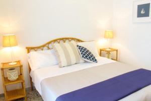 1 dormitorio con 1 cama blanca grande y 2 lámparas en Rosa Dei Venti Ponza en Ponza
