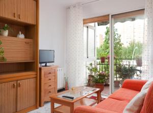 Bright apartment close to congress center & port في برشلونة: غرفة معيشة مع أريكة وتلفزيون