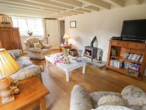 uma sala de estar com sofás e uma lareira em Quoits Cottage em Beck Hole