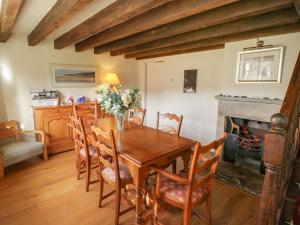 uma sala de jantar com uma mesa de madeira e uma lareira em Quoits Cottage em Beck Hole