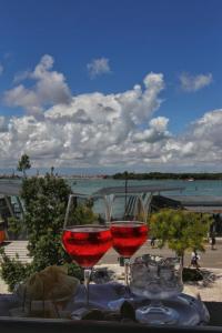 two glasses of wine on a table with a view of the beach at Hotel Belvedere in Venice-Lido